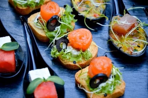 Závitky z lososa a salátem na toastu na cateringovém stole